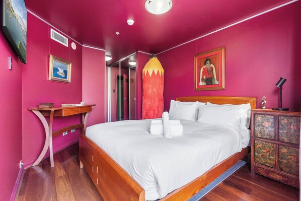 A room with a wooden bed, a nightstand, a dresser, and a mirror. - Artsy Boho Den in Iconic Fingerwharf, Woolloomoolo (Woolloomooloo)
