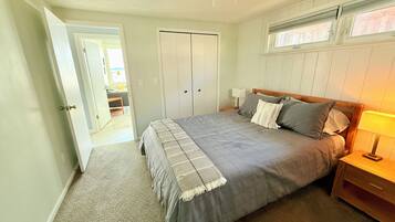 A bedroom with a bed, nightstands, a ceiling fan, and a wardrobe.