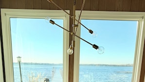 En matplats med ett bord, stolar och utsikt över en sjö.