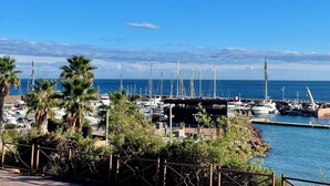 A marina with boats docked, surrounded by palm trees and a clear blue sky. - Enchanting beach house in Théoule-sur-Mer directly on the Plage de la Figueirette (Théoule-sur-Mer)