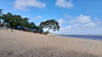 Vlak bij het strand, wit zand, parasols, strandlakens