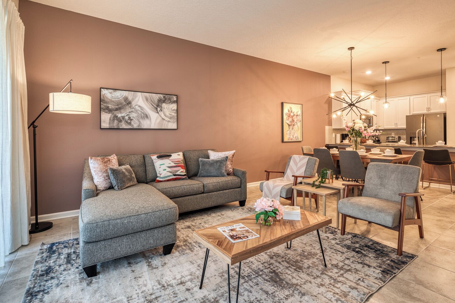 A modern living room with a sectional sofa, a coffee table, and a dining area with chairs.