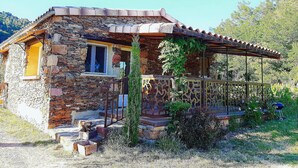 A stone house with a wooden porch and a metal railing. - Magnificent Cottage in Payzac With Pool ! (Payzac)