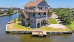 A waterfront house with a wooden deck, a staircase, and a dock. - Canalfront Dog Friendly Home w/ Hot Tub, Private Boat Ramp/Dock, Cargo Lift (Avon)