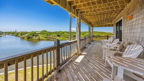 A wooden deck with a railing overlooking a body of water, surrounded by greenery. - Canalfront Dog Friendly Home w/ Hot Tub, Private Boat Ramp/Dock, Cargo Lift (Avon)