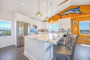 A modern kitchen with a central island, stainless steel appliances, and a view of the city.