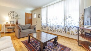 A living room with a sofa, coffee table, and a clock on the wall. - Midtown Comfort & Convenient home -  3 bedrooms in Dubuque (Dubuque)