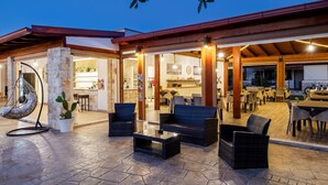 An outdoor patio area with wicker furniture, stone flooring, and a view into the interior of a building. - Apartment in Vieste With Garden (Vieste)