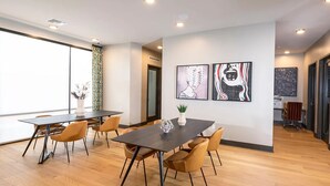 Una sala de reuniones moderna con una mesa grande, sillas cómodas y obras de arte en las paredes.