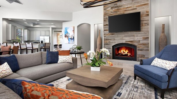 A modern living room with a fireplace, a sofa, a coffee table, and a TV mounted on the wall.