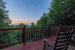 A wooden deck with a railing overlooking a forested area. - Stunning Views, Games, and Relaxation! (GATLINBURG)