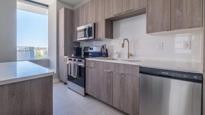 A modern kitchen with a built-in oven, microwave, and dishwasher. - Landing | Amazing 2BD in Fountain Heights (Birmingham)