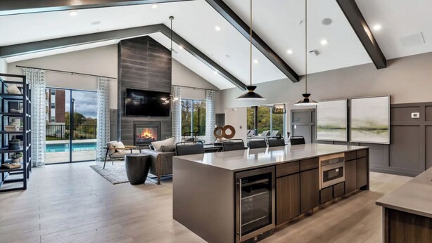 A modern kitchen with a large island, a fireplace, and a dining area with a pool view. - Landing | Chic 1BD, Pool, Clubhouse (Willow Springs)