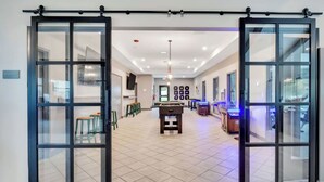 A spacious room with a pool table, bar area, and a game room. - Landing | Chic 1BD, Pool, Clubhouse (Willow Springs)