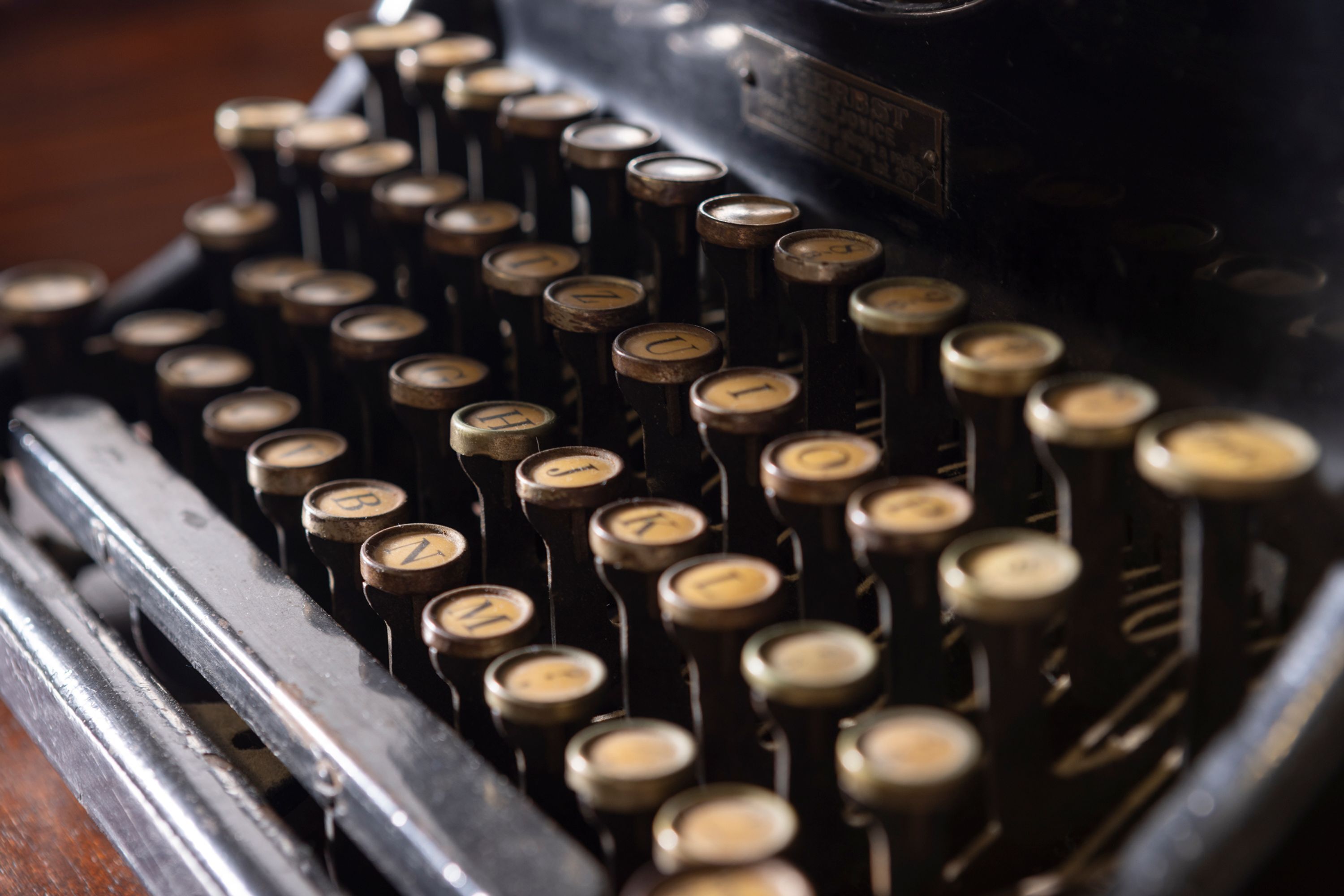 A close-up of a vintage typewriter with keys labeled with letters and symbols.