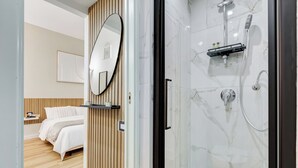 Een moderne badkamer met een douchecabine van glas, een zwarte handdoekhouder en een wand van hout.