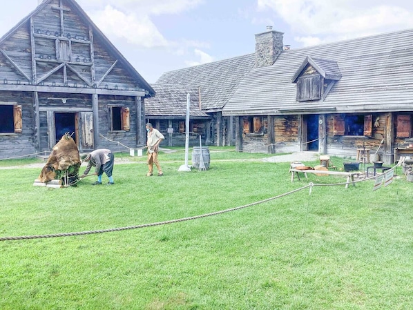 Een rustieke schuur met een schuin dak en een houten constructie met schoorsteen.