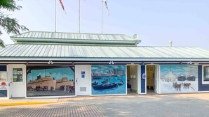 Un edificio con techo verde y varios murales que representan escenas marinas.