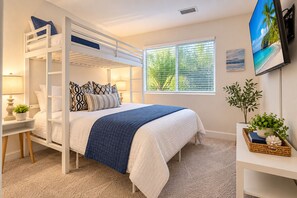 A bunk bed room with a window, a bedside table with a lamp, and a TV on the wall. - Seaside Escape + Walk to Encinitas Beach + Wifi + Free Parking (Encinitas)