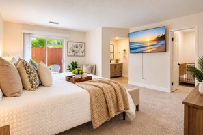 Sink into the plush bed and let your worries fade away in this serene bedroom. Large windows frame lush palms just outside, while soft neutral tones and cozy textures create your private retreat.