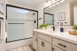 Refresh in your modern bathroom, where clean lines meet thoughtful details—crisp white surfaces, a spacious vanity, and a sleek glass-enclosed shower ready to ease away the day.