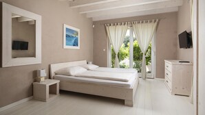 A bedroom with a bed, bedside table, TV, and a window with curtains. - Villa Bella near the sea with Private Pool, Sauna, and Hot Tub (Ližnjan)
