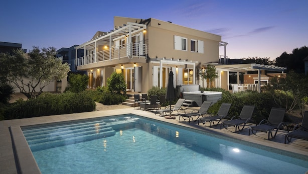 A modern two-story house with a swimming pool, outdoor seating, and a well-lit patio area. - Villa Bella near the sea with Private Pool, Sauna, and Hot Tub (Ližnjan)