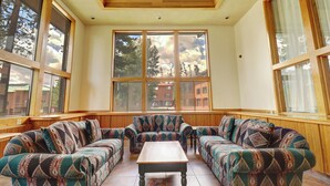 A sunroom with a large window, a wooden ceiling, and a patterned sofa set. - Beautiful Home with views of Lake Dillon, 727B (Frisco)