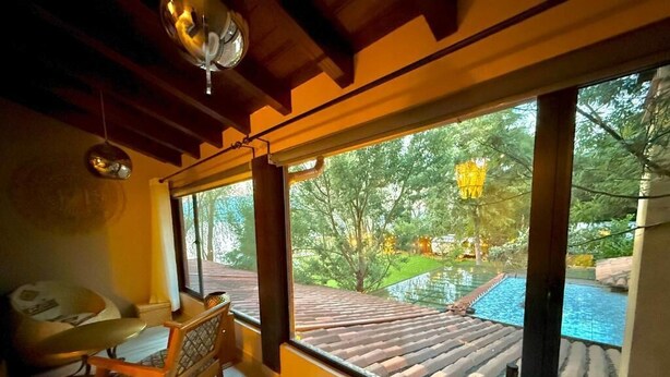 A room with a large window, a bathtub, and a wooden chair. - Hotel Boutique La Casa Del Lago (Tzintzuntzan)