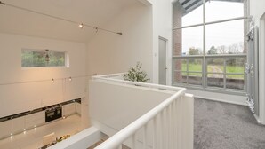 A modern kitchen with a gas stove, a built-in oven, and a large window overlooking a garden. - Manchester House Retreat (Manchester)