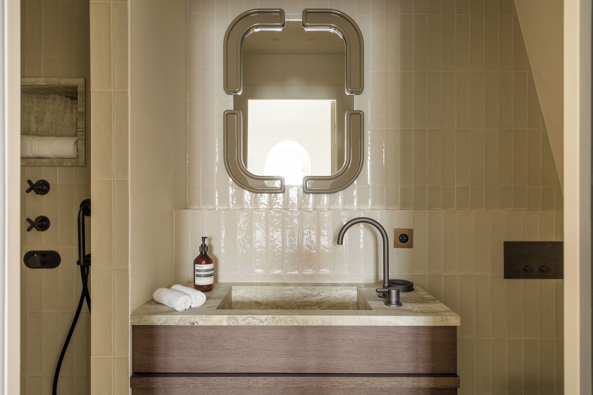 Une salle de bain avec un grand miroir, un lavabo et une douche.