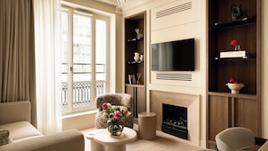 A modern living room with a fireplace, a flat-screen TV, and a comfortable seating area. - HIGHSTAY Maison - Boétie (Paris)
