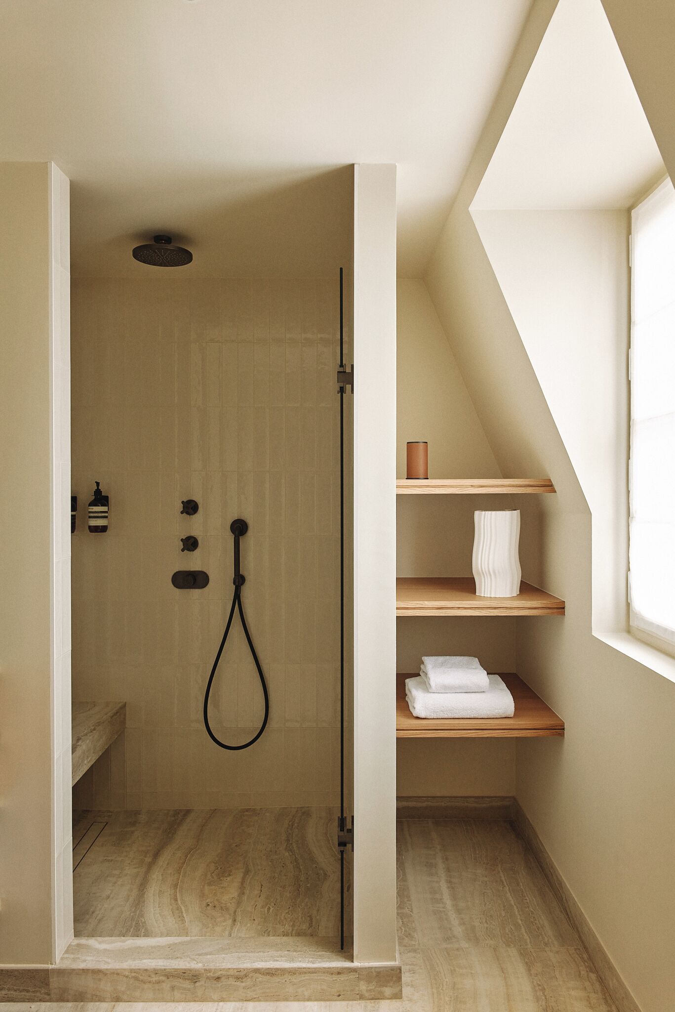 Een kleine, moderne badkamer met een douche, een handdoekrek en een plank met een handdoek.