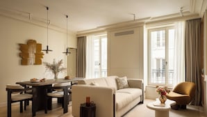 A modern living room with a sofa, coffee table, and dining table. - HIGHSTAY Maison - Boétie (Paris)