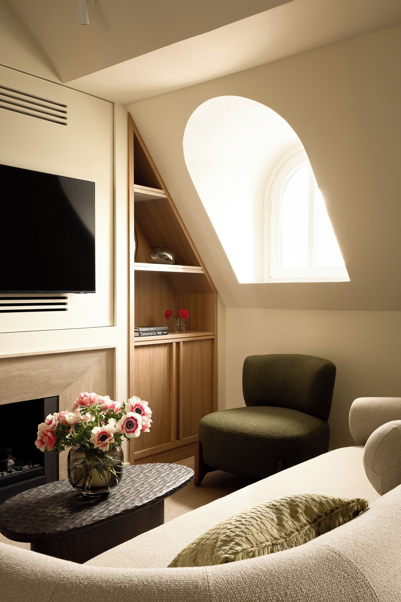 Ein modernes Wohnzimmer mit Flachbildfernseher, Kamin, Oberlicht und einer gemütlichen Sitzecke.