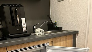 Un frigorifero compatto dotato di congelatore, fabbricatore di ghiaccio integrato e dispenser per acqua.