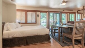Un dormitorio con una cama, una mesa de comedor y sillas.