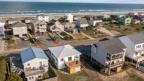 A coastal residential area with houses, a road, and a beach in the background. - Cozy beach studio- Bottom unit (Holly Ridge)