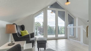 Amplia habitación con techo alto, ventana grande y balcón.