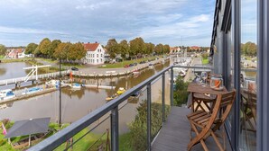 Un balcón con vista a un río, barcos y edificios.