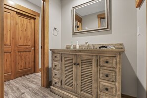 A wooden cabinet with drawers and a mirror above it. - The Wildrose | Hocking Hills, Hot Tub, Karaoke (Logan)