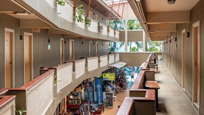 Un interior de varios niveles con balcones, un pasillo central y una zona comercial.