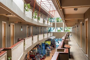 Un espace intérieur à plusieurs niveaux, doté de balcons, d’une allée centrale et d’une zone commerciale.
