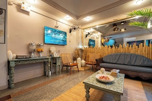 Un salon chaleureux avec un canapé, une table basse, un téléviseur et un mur décoratif.