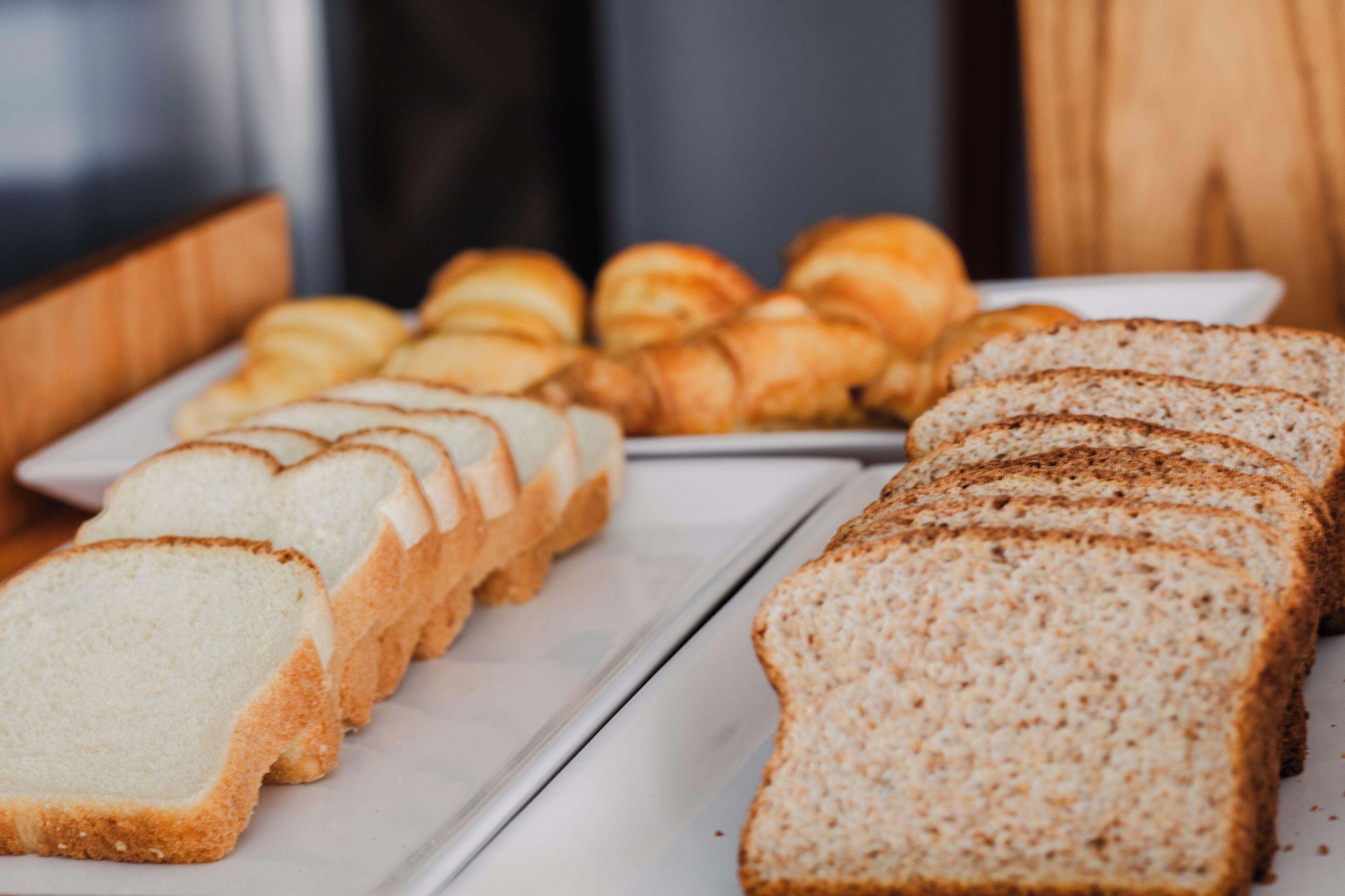 A variety of bread and pastries on a white tray.