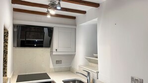 A kitchen with a built-in oven, a sink, and a ceiling fan. - 2 bedroom accommodation in Addingham, near Ilkley (Addingham, near Ilkley)