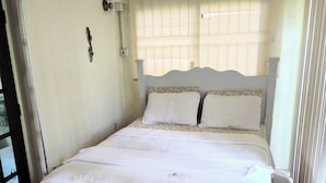 A single bed with a quilted bedspread, a headboard, and a window with blinds. - Condo - 2 beds with WiFi, AC, Pool and Oceanfront in charming Frigate Bay. (Frigate Bay)