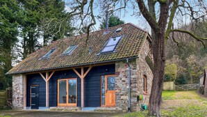 A stone house with a tiled roof and a large window. - 2 bedroom accommodation in Clevedon (Clevedon)