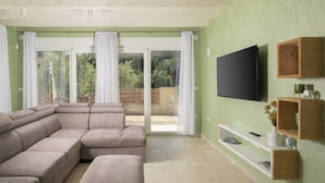 A living room with a sectional sofa, a flat-screen TV, wooden shelves, and a sliding glass door leading to an outdoor area. - Villa Olivia with Private Pool, Sauna, and Hot Tub – Just 800m from the Beach (Ližnjan)