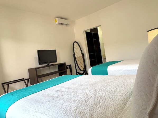 A hotel room with two beds, a television on a stand, a door, and an air conditioning unit. - Hotel Aria Quinta Avenida & Rooftop Playa del Carmen (Playa del Carmen)